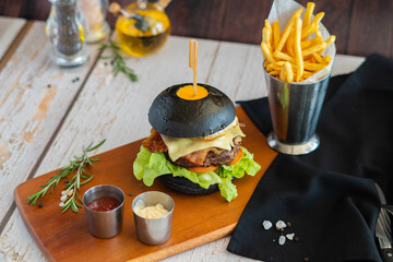 Beef burger cheese volcano with chips on wooden board