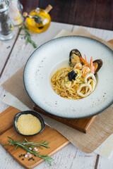 Seafood spaghetti with garlic cheese and white wine on wooden board