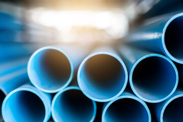 Close up to blue plastic pipe background, PVC pipes stacked in warehouse,  PVC water pipes used for construction - obrazy, fototapety, plakaty