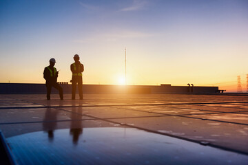 Technician Team checking Photovoltaic cells panels on factory roof, Maintenance of the solar panels, Engineer service, Inspecor concept. Silhouette Photo. © KL 1981