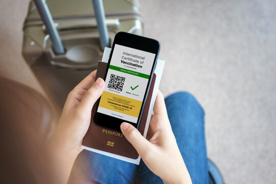 Disease immunity passport, Tourist uses of application on smartphone to show an international certification of vaccination at airport with Immunity passport and vaccination record card for covid-19
