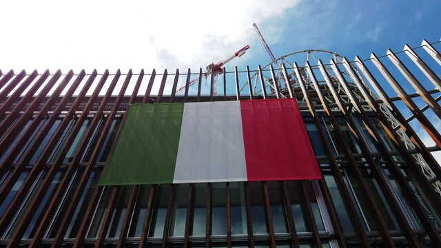 Europe, Italy , Milan July 2021 - italian flags after the victory of the European cup -Italy football club in Gae Aulenti Porta Nuova - new building skyscraper construction with gru crane at work