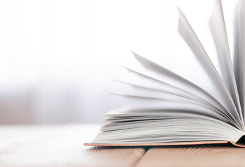 open book on the wood table in the white blurred background with copy space