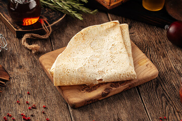 Folded armenian pita bread lavash on the wooden background