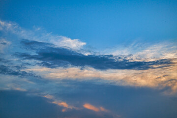Summer evening sky in the picturesque clouds, lit by the rays of the setting sun.
