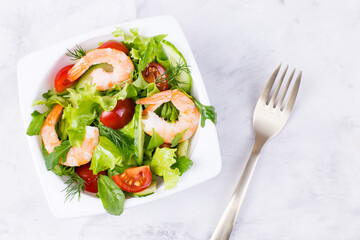 Delicious and healthy shrimp salad with herbs and tomatoes. Dietary nutrition for weight loss. Recipe for cooking fresh seafood. Mediterranean cuisine.