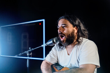 A young Hispanic man singing passionately and playing the guitar at a concert