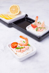 Delicious shrimp canapes with tomato and arugula on a light background. Festive appetizer with seafood.