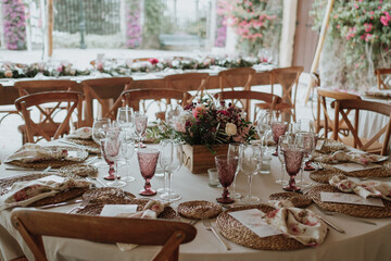 Rustic wedding setting table with flowers and colorful glasses on a wooden table