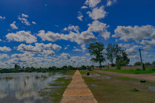 parque al aire libre con lugar para sentarse al costado de una laguna artificial, Castelli - Chaco - Argentina