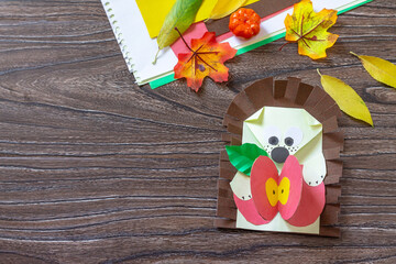 Autumn Greeting postcard hedgehog with an apple on a wooden table. Handmade. Project of children's creativity, handicrafts, crafts for kids. © elena_hramowa