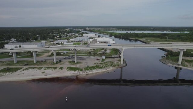 Aerial flying parallel to bridge and highway over intracoastal and bay