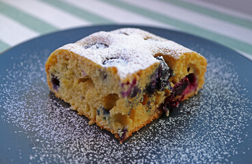 Closeup of a Slice of Mouthwatering Blueberry Cake Sprinkled with Icing Sugar