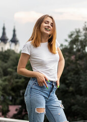 Outdoor portrait of smiling young woman in casual clothing.