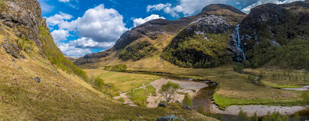 A panorama view from the upper reaches of the valley wall towards the Steall Waterfall in Glen Nevis, Scotland on a summers day