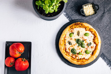 Traditional Margherita Pizza with basil, tomato, olive oil, mozzarella on a rustic background
