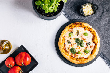 Traditional Margherita Pizza with basil, tomato, olive oil, mozzarella on a rustic background