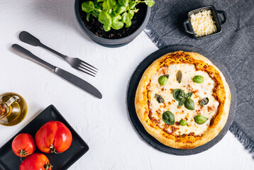 Traditional Margherita Pizza with basil, tomato, olive oil, mozzarella on a rustic background