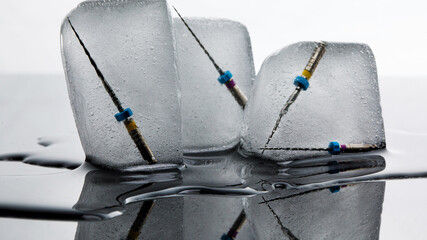 three pieces of ice with composition of endodontic instruments on a white background