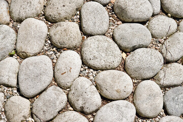 Texture of large smooth stones decoratively laid out on the ground. Landscape design fragment.