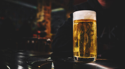 man hold a glass of beer in his hand at the bar or pub