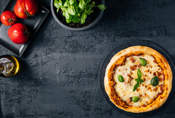 Traditional Margherita Pizza with basil, tomato, olive oil, mozzarella on a rustic background