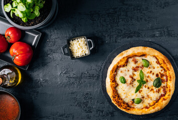 Traditional Margherita Pizza with basil, tomato, olive oil, mozzarella on a rustic background