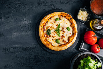 Traditional Margherita Pizza with basil, tomato, olive oil, mozzarella on a rustic background