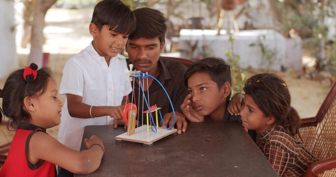 Group Of South Asian Children And A Teacher Playing With Educational Toys