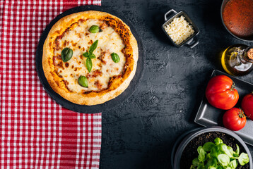 Traditional Margherita Pizza with basil, tomato, olive oil, mozzarella on a rustic background