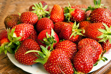Ripe strawberries in a plate. Fresh berries, fragrant . Old wooden table in a rustic style, close-up