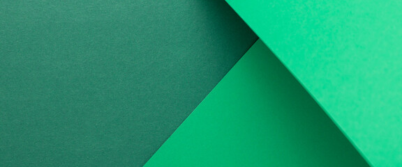 Green cardboard background design folded geometrically. Top view, flat lay. Banner