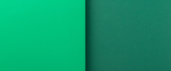 Two shades of green cardboard background. Top view, flat lay. Banner