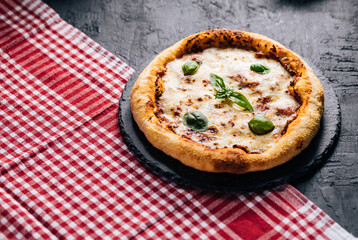 Traditional Margherita Pizza with basil, tomato, olive oil, mozzarella on a rustic background