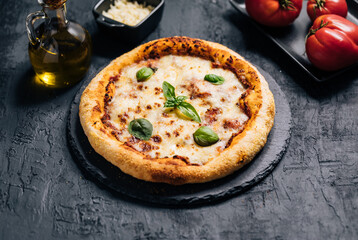 Traditional Margherita Pizza with basil, tomato, olive oil, mozzarella on a rustic background