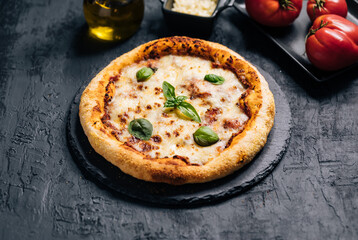 Traditional Margherita Pizza with basil, tomato, olive oil, mozzarella on a rustic background