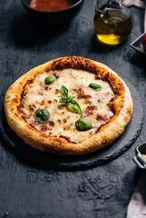 Traditional Margherita Pizza with basil, tomato, olive oil, mozzarella on a rustic background