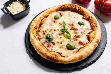 Traditional Margherita Pizza with basil, tomato, olive oil, mozzarella on a rustic background