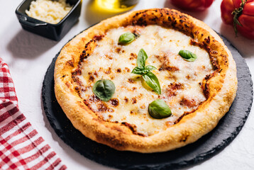 Traditional Margherita Pizza with basil, tomato, olive oil, mozzarella on a rustic background
