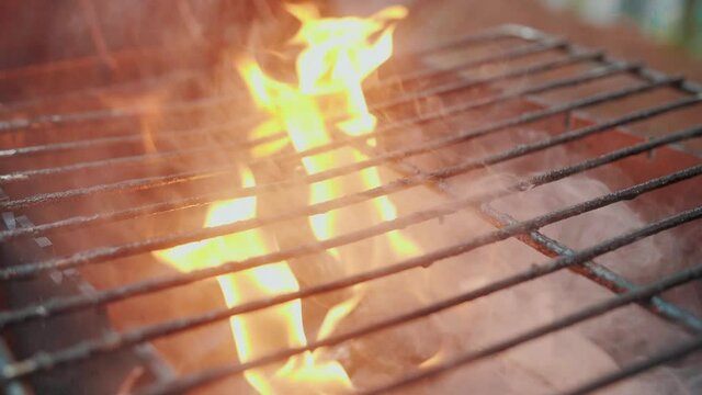 Empty hot barbecue grill with a flame of fire and smoke is burning, super slow motion.