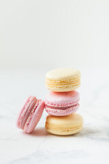 Fototapeta na wymiar Stack of yellow and pink macaroons with shallow depth of field on the white background.