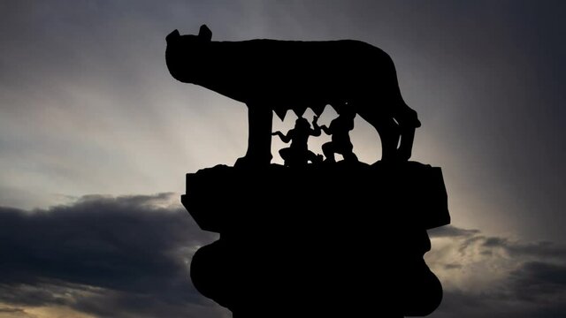 She-Wolf Breastfeeding Romulus and Remus , Time Lapse at Sunrise with Fast Clouds and Dark Silhouette of Roman Symbol, Italy