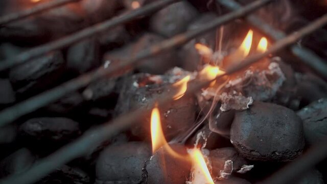 Empty hot charcoal barbecue BBQ grill with a large flame of fire and smoke is burning in restaurant. Super slow motion. Close up.
