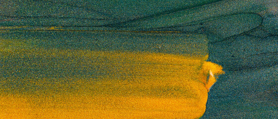 Abstract golden background. Strokes of gold paint on a green background. Gold glittering smear on a...