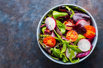 Salad with cherry tomatoes, radish and mix salad. Healthy salad, leaves mix salad. Paleo diet concept. Copy space. Top view