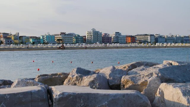 The coastline of an empty beach in Italy during beautiful summer sunset. No tourists at the beach due to travel restrictions during the Covid-19, Coronavirus pandemic. Caorle, Veneto. 4K.