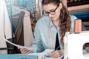 Creative female fashion designer draws sketches drafts