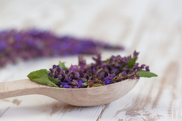 Fototapeta premium sage flowers in a wooden spoon close-up. the concept of homeopathy, aromatherapy, natural cosmetics.