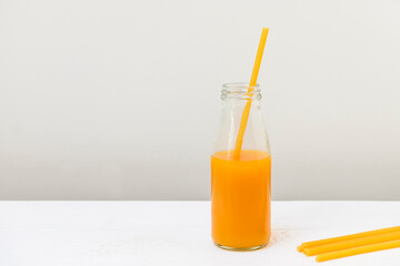 Pasta straw in a glass bottle with peach juice, zero waste concept