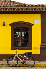 Historic Center of Cananéia, São Paulo, Brazil. Window of a yellow house with colonial...